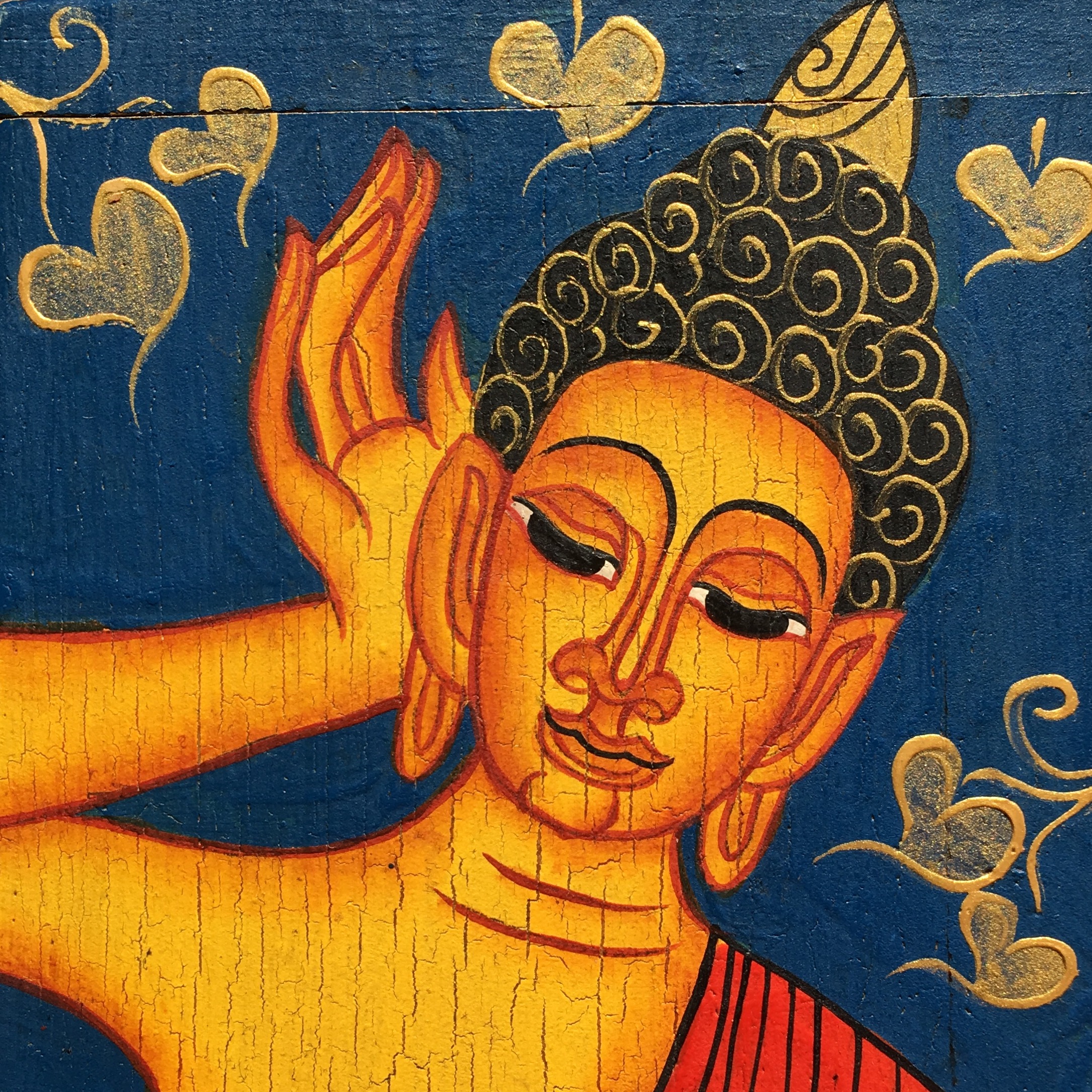 Buddha Ikonenbild Orange auf Blau mit rotem Gewand hält sich eine Hand gewölbt ans Ohr